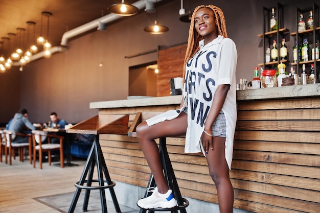 Linda mulher africana em roupas casuais elegantes posando perto do balcão de bar