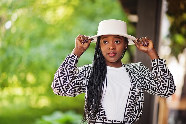 Linda mulher afro-americana maquiagem natural usar roupas de moda casual preto e branco código de vestimenta estilo de escritório total blusa e calça terno e chapéu