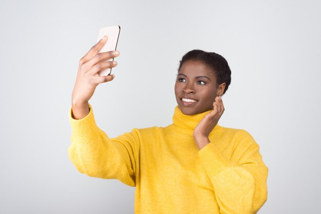 Linda mulher afro-americana tomando selfie com smartphone