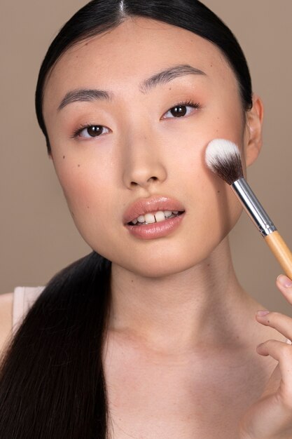 Linda mulher asiática aplicando maquiagem