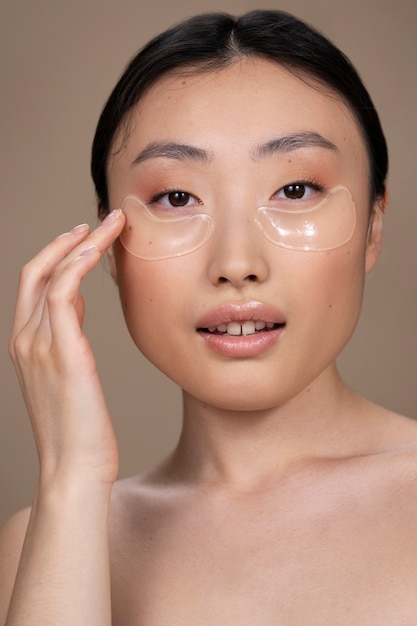 Linda mulher asiática aplicando tratamento de pele