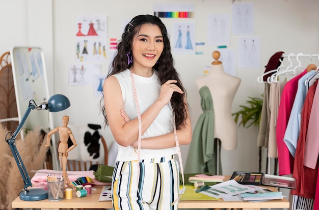 Linda mulher asiática designer de moda posa no conceito de negócio de empresário de estúdio de escritório