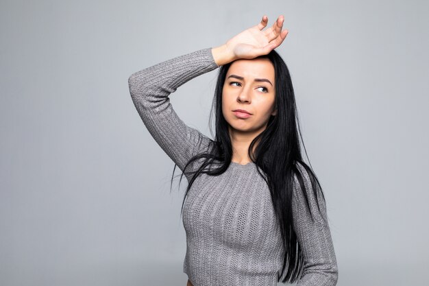 Linda mulher cansada no trabalho, isolado em uma parede cinza