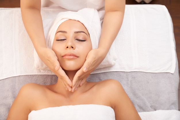 Linda mulher caucasiana, recebendo anti idade massagem no salão spa