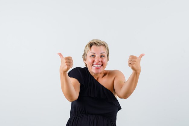 Linda mulher de blusa preta aparecendo o polegar e parecendo feliz