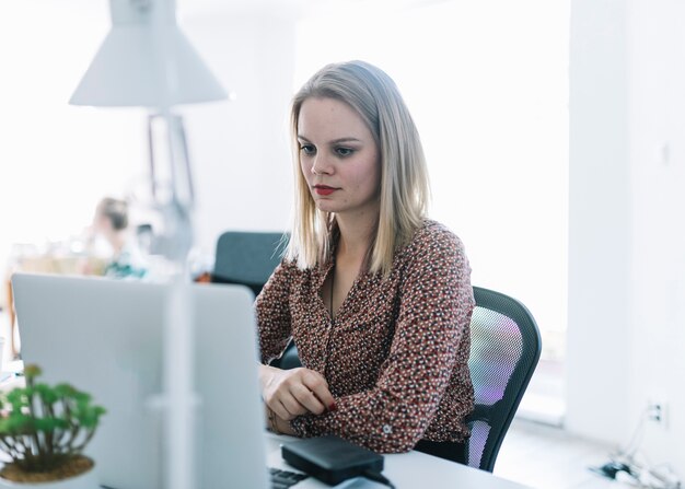 Linda mulher de negócios olhando para laptop