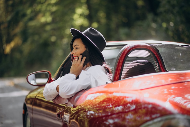 Foto grátis linda mulher dirigindo um cabrio vermelho
