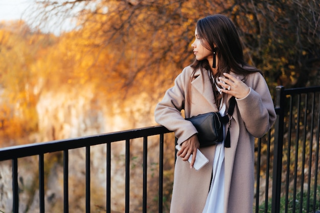 Foto grátis linda mulher elegante em pé em um parque no outono