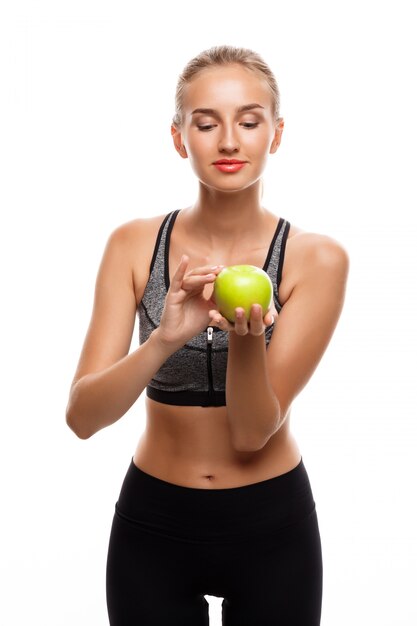 Foto grátis linda mulher esportiva posando, segurando a maçã