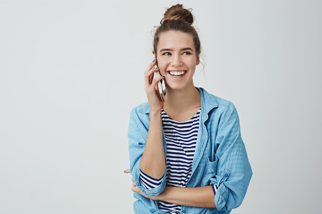 Foto grátis linda mulher europeia feminina rindo falando telefone casualmente