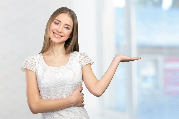 Linda mulher feliz e sorridente mostrando o espaço da cópia