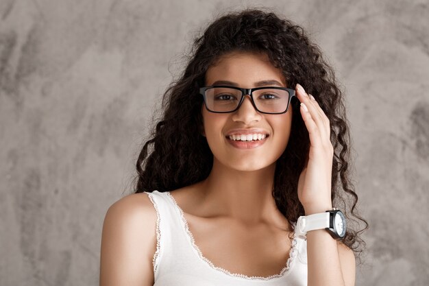 Linda mulher hispânica encaracolada em copos, sorrindo