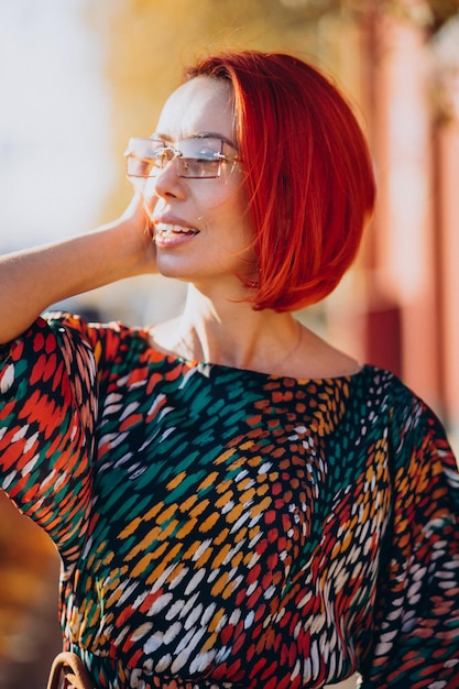 Linda mulher idosa em um vestido colorido do lado de fora da rua de outono