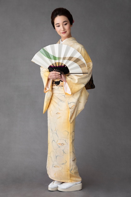 Linda mulher japonesa com um leque minimalista