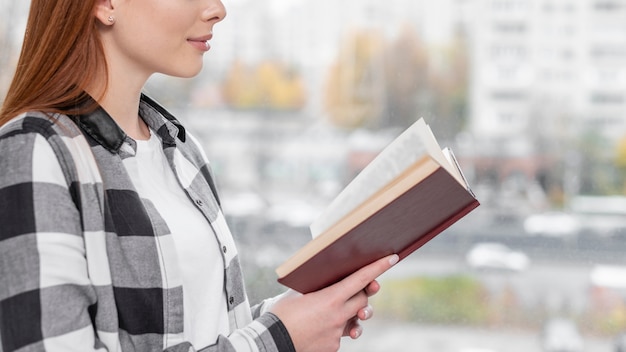 Foto grátis linda mulher lendo livro vista lateral