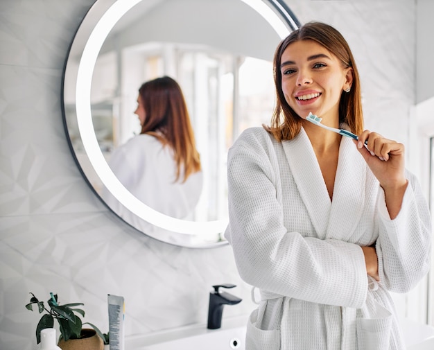 Linda mulher segurando sua escova de dente