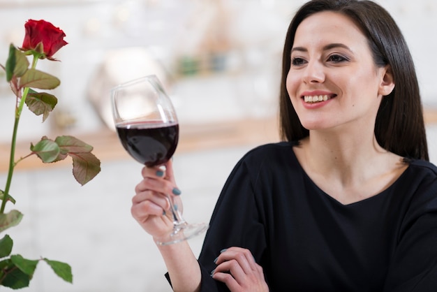 Foto grátis linda mulher segurando um copo de vinho tinto