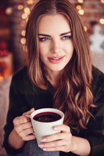 Linda mulher segurando uma caneca de vinho quente com gengibre