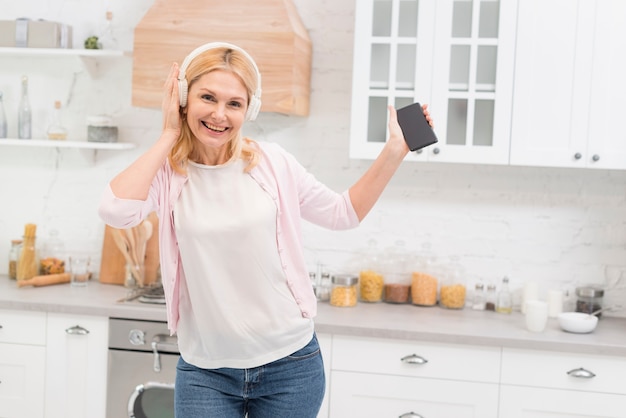 Linda mulher sênior ouvindo música em casa