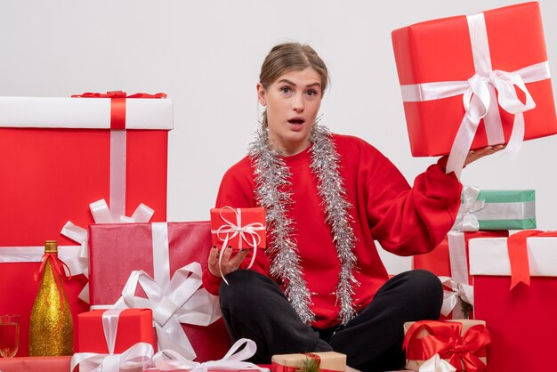 Linda mulher sentada em volta de presentes de natal em branco