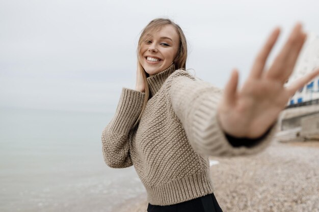 linda mulher sorridente aconchegante ao ar livre perto do mar