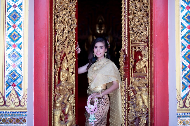 Linda mulher tailandesa em traje tradicional no templo da Tailândia