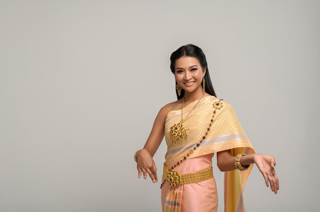 Linda mulher tailandesa usando vestido tailandês e dança tailandesa