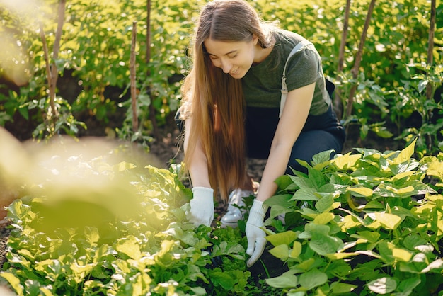 Foto grátis linda mulher trabalha em um jardim perto da casa