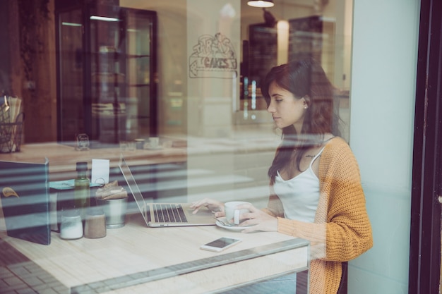 Foto grátis linda mulher usando laptop no café