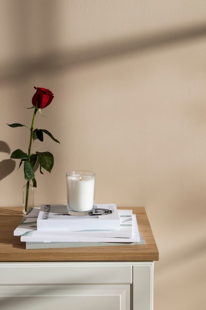 Foto grátis linda rosa e arranjo de livros na mesa