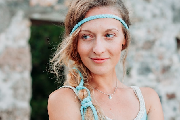 Linda senhora de pé e sorrindo em vestido longo azul durante o dia.