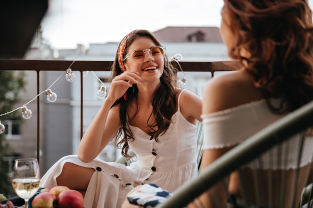 Foto grátis linda senhora de vestido branco fala com a amiga