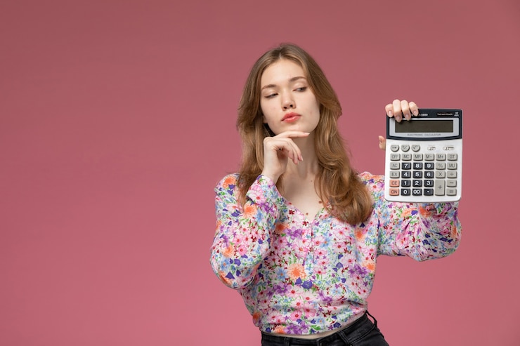 Foto grátis linda senhora olhando para a calculadora de frente