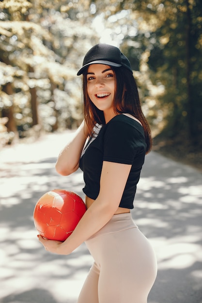 Linda sportsgirl em um parque ensolarado de verão