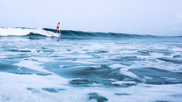 linda surfista montando em uma placa