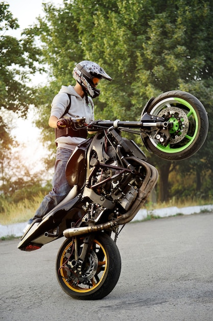 Foto grátis linda vista lateral de um motociclista andando de motocicleta de maneira extrema