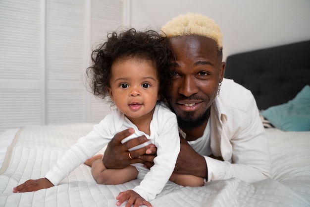 Foto grátis lindo bebê preto em casa com os pais