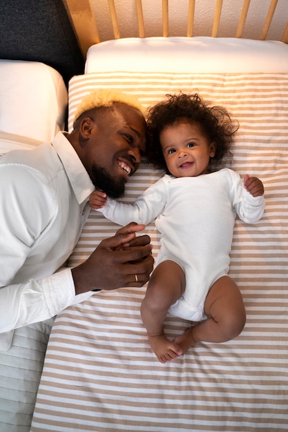 Foto grátis lindo bebê preto em casa com os pais