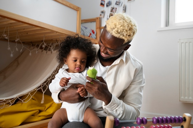 Foto grátis lindo bebê preto em casa com os pais