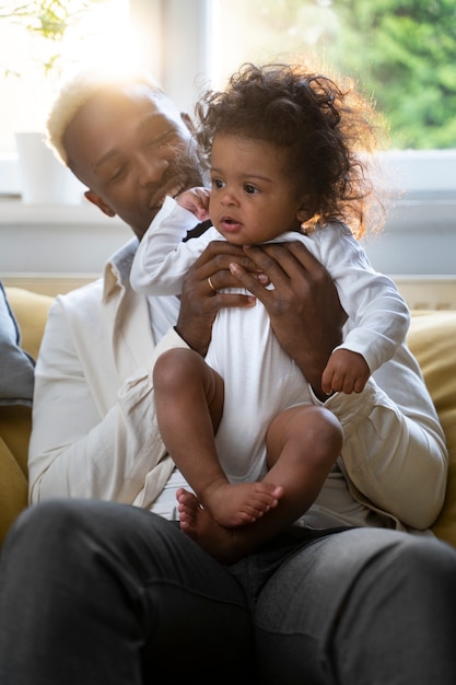 Foto grátis lindo bebê preto em casa com os pais