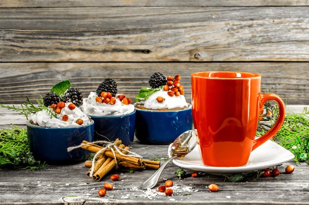 lindo bolinho de Natal com creme e frutas vermelhas na mesa de madeira cones de canela