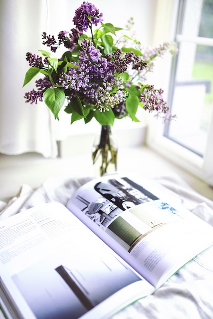 Lindo buquê de flores roxas com uma revista aberta