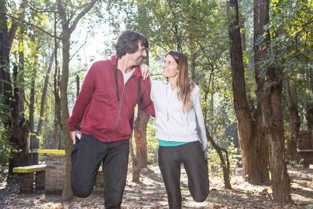 Lindo casal alongamento dos músculos antes da actividade desportiva