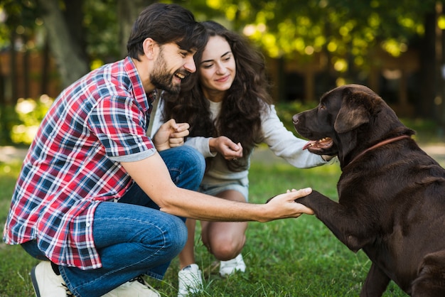 Lindo casal amando seu cachorro no parque