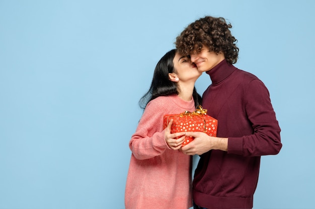 Foto grátis lindo casal apaixonado na parede azul do estúdio