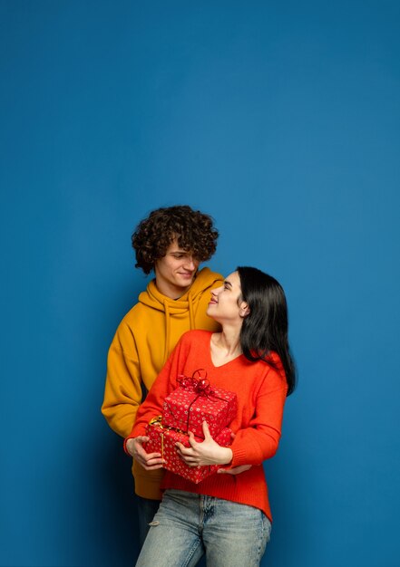 Lindo casal apaixonado na parede azul do estúdio