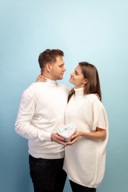 Lindo casal apaixonado na parede azul do estúdio