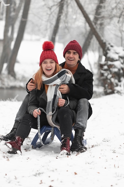 Foto grátis lindo casal brincando com o trenó