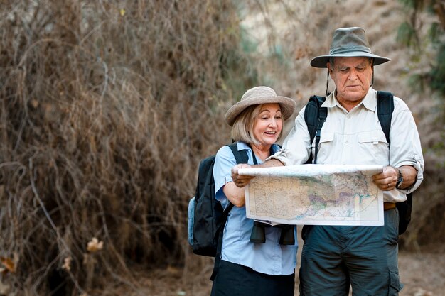 Lindo casal de idosos usando um mapa para buscar orientação