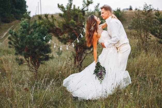 Lindo casal de noivos em um campo de verão